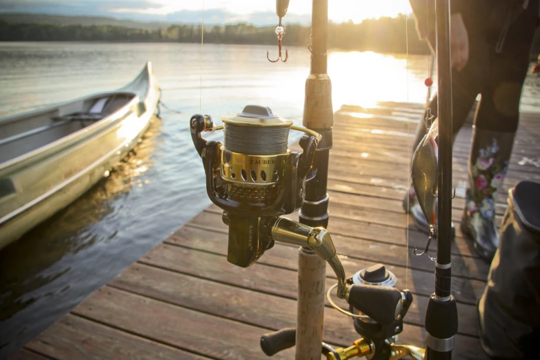 the sun is setting behind the fishing poles