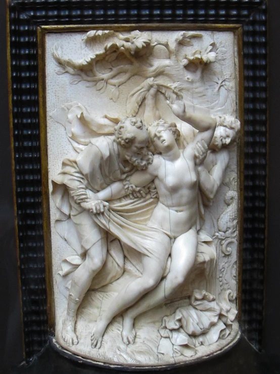 a sculpture of two men emcing in the middle of a panel