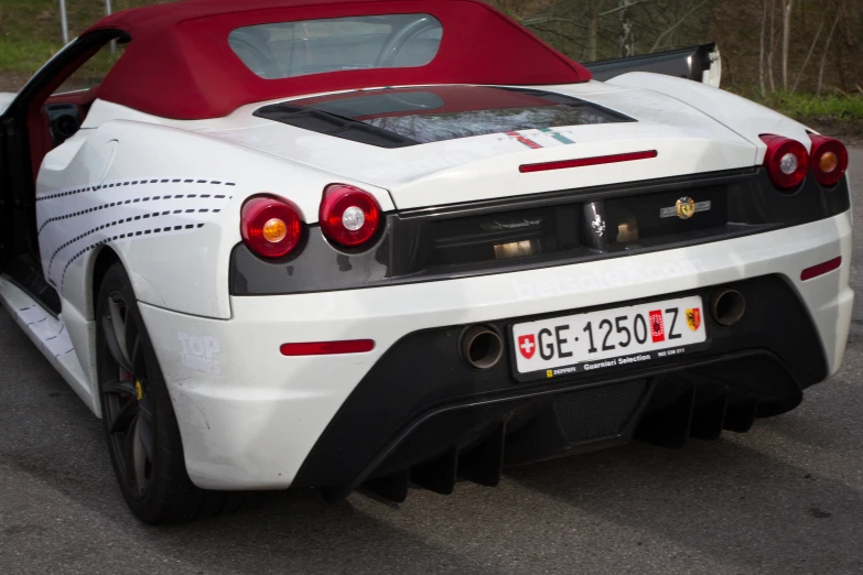 the rear of a white sports car with its hatch open