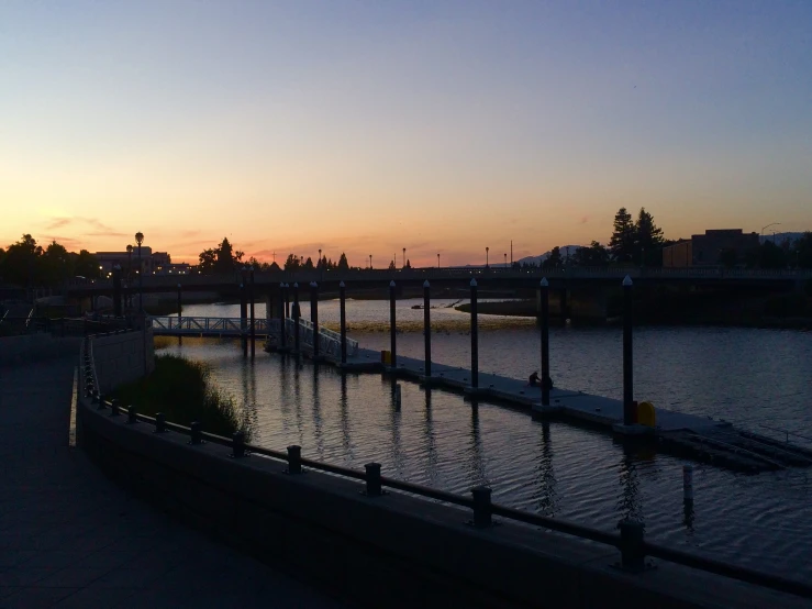 sunset in a town over water and a bridge