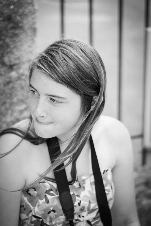 a girl wearing a tie outside near a fence