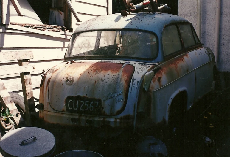 an old rusty car with a can of soda in the back