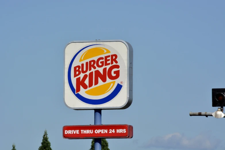 burger king sign above a traffic light, near a tree