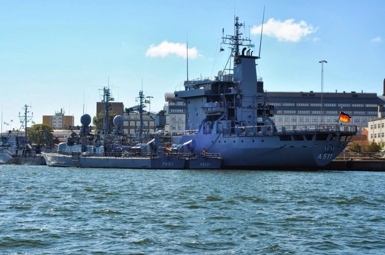 two large ships are parked close together by the shore