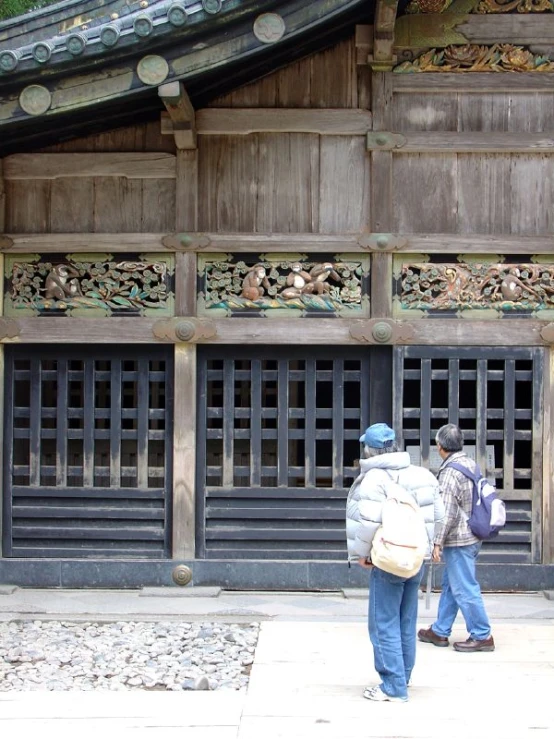 a man and woman are walking towards an old style building