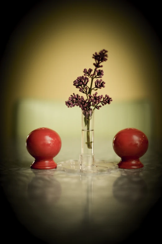 a small vase with flowers in it next to two smaller ones