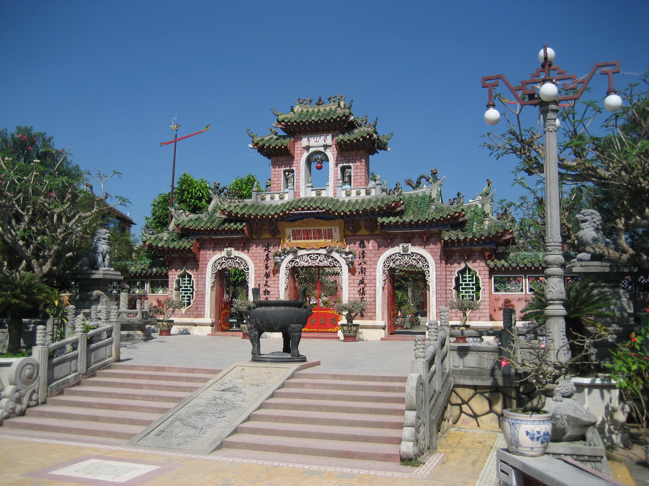 an asian styled temple is decorated in pink, white and red