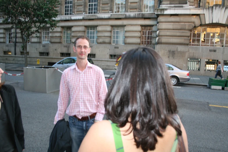 three people walking down a street talking to each other