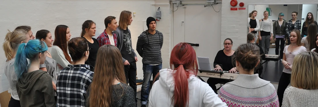 a group of people standing around a piano