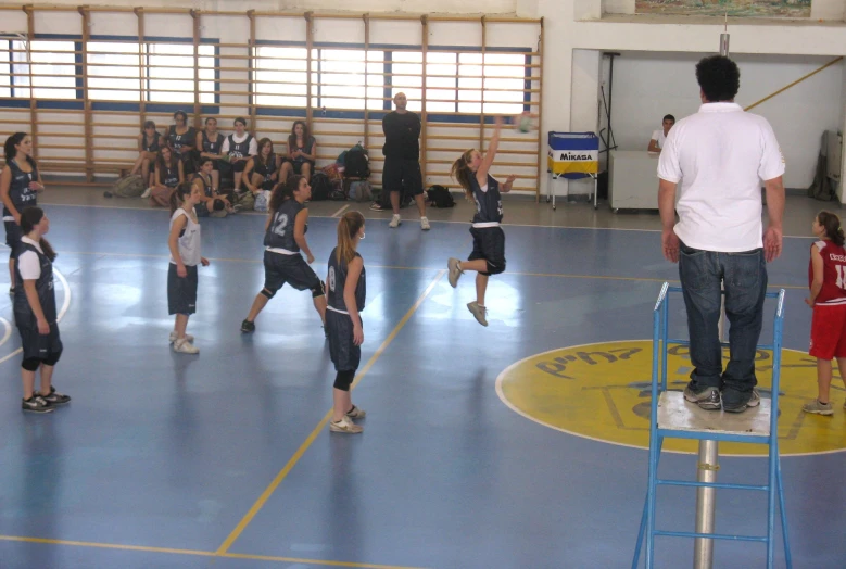 some people are playing with a child on a basketball court