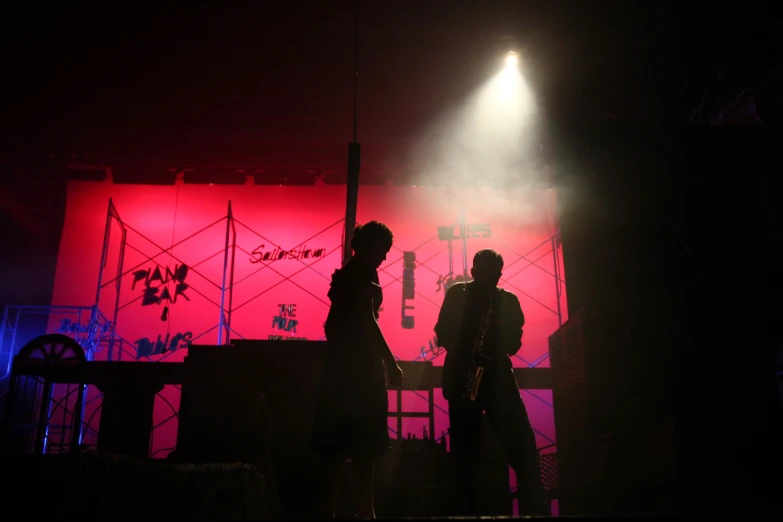 a man standing on stage under a beam