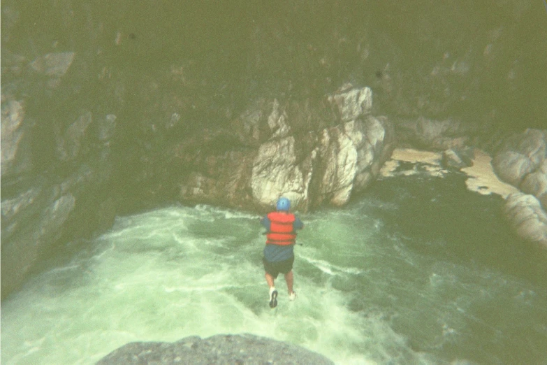 man standing at the top of an island while looking down on rapids