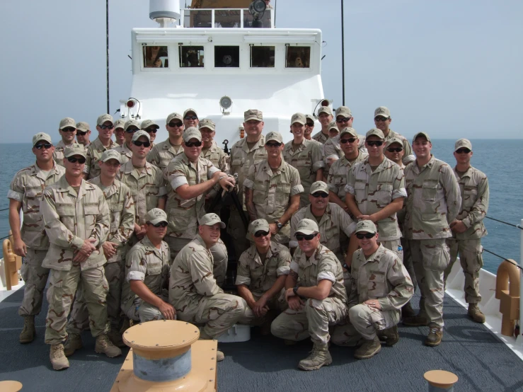 a group of men in uniform standing on top of a boat