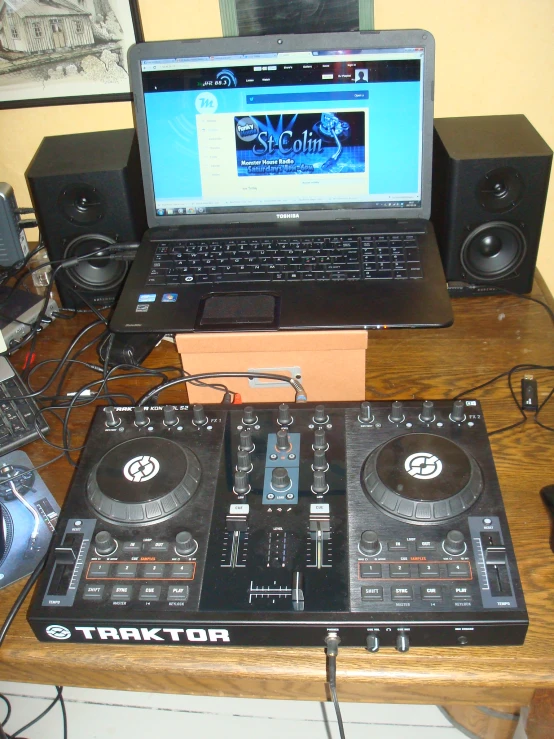 a laptop on top of a table with dj equipment