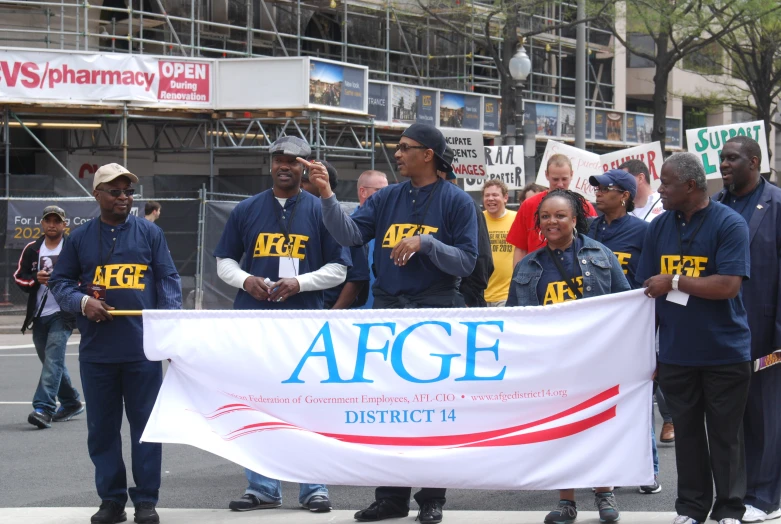 people standing behind an afge banner during a protest