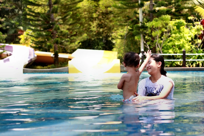 a woman and child sitting in the middle of a swimming pool