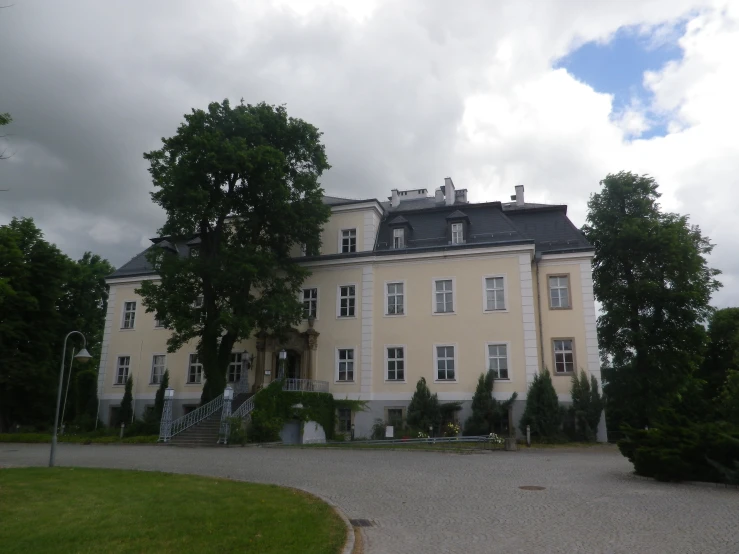 a white building with trees on both sides