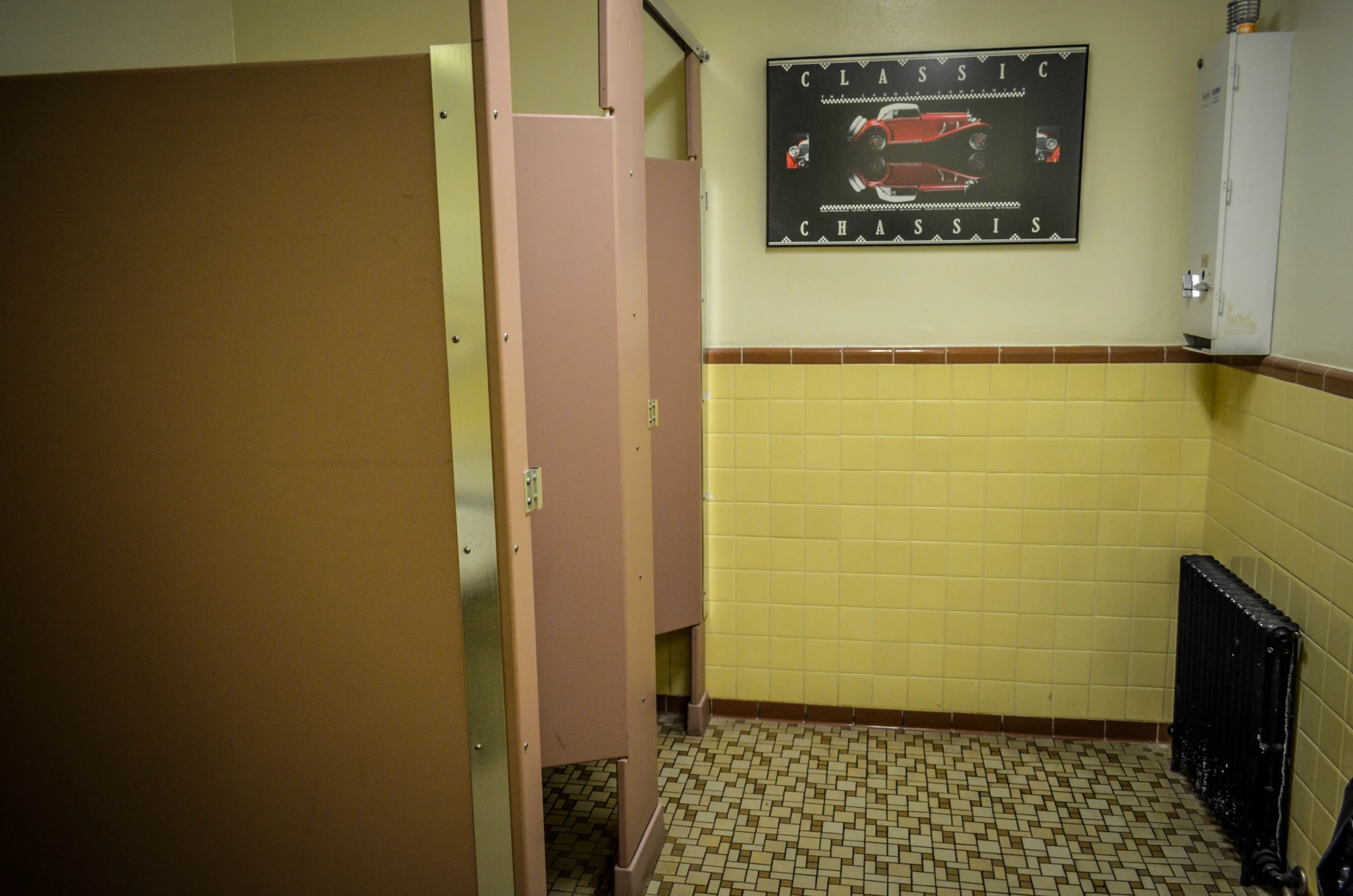 a bathroom with yellow walls and brown tile