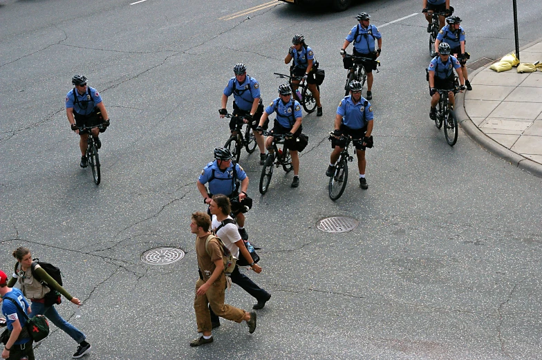 a bunch of cops on bikes riding down the street