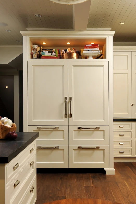 this is a kitchen with white cabinets and wooden floors