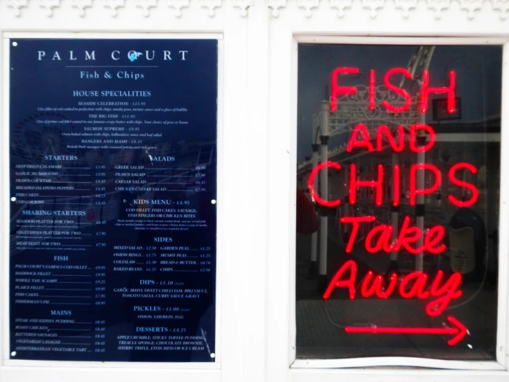 a restaurant window display featuring a fish and chips take away menu