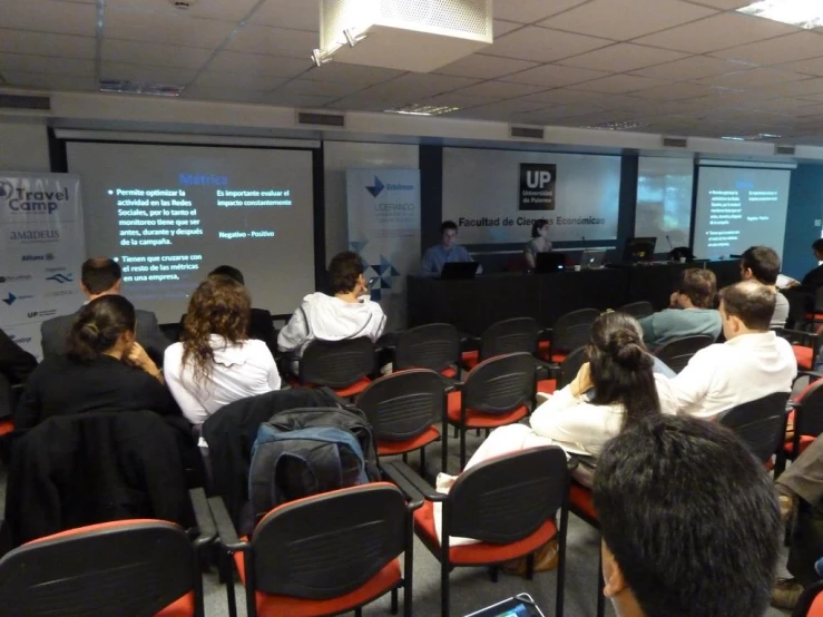 people in chairs are watching a presentation