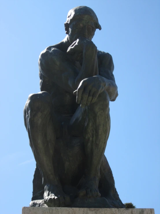 a bronze statue that is sitting down