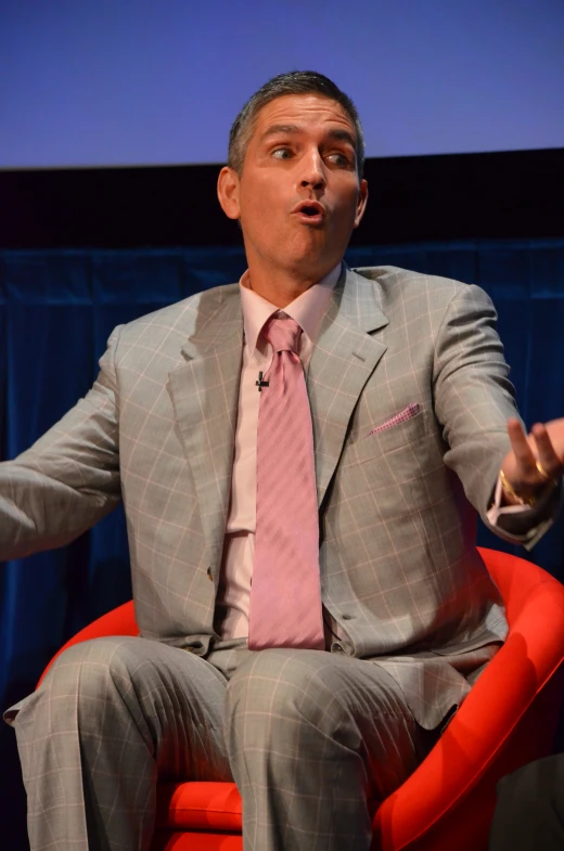 man in suit and tie sitting on a chair