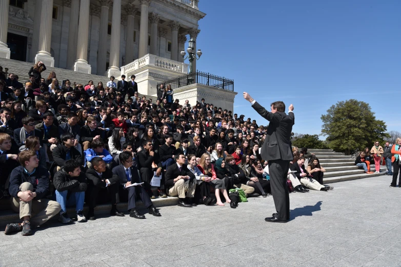 a man standing on top of steps in front of a crowd