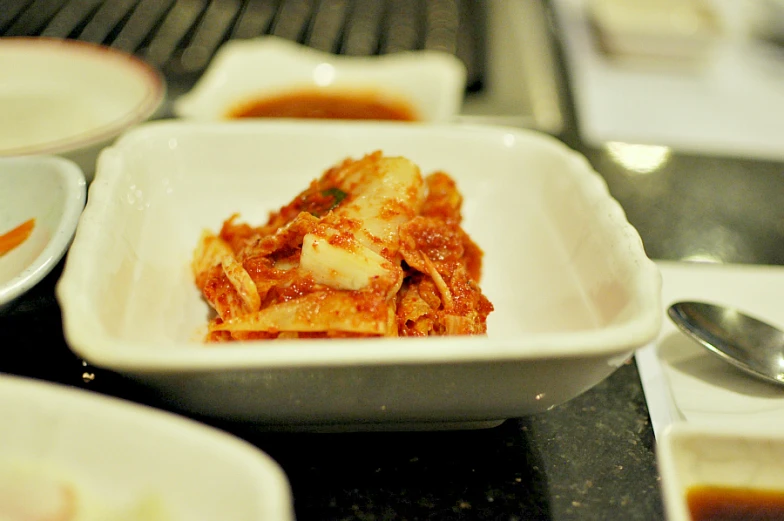 food with onions and sauce in small white bowls