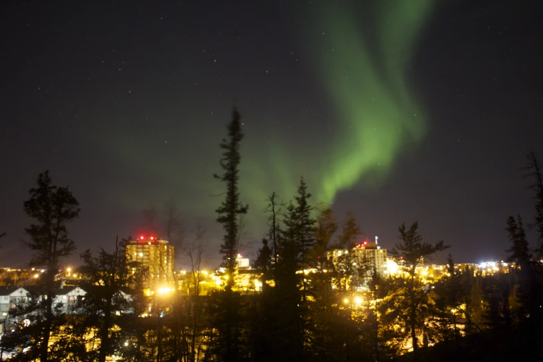 green light shines through the dark night sky