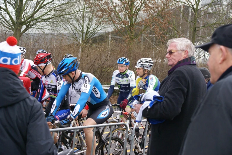 people are riding bicycles around a fenced in area