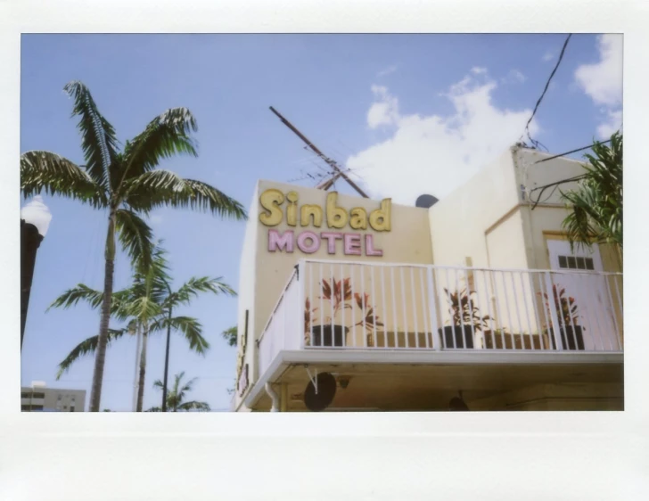 a motel with palm trees next to it