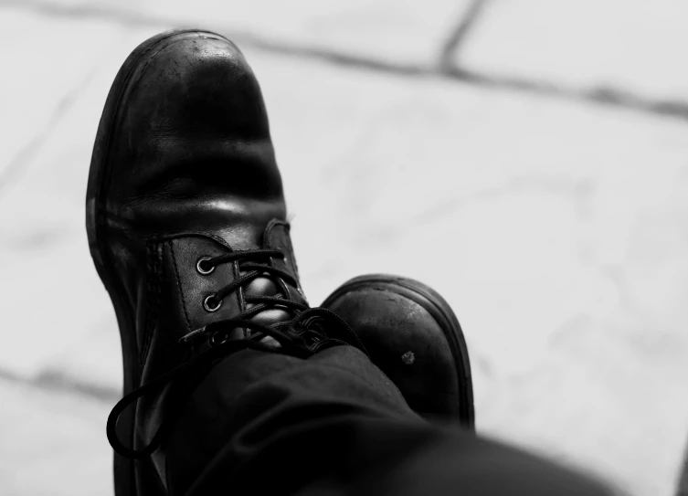 the feet and shoes of a man in black on a marble floor