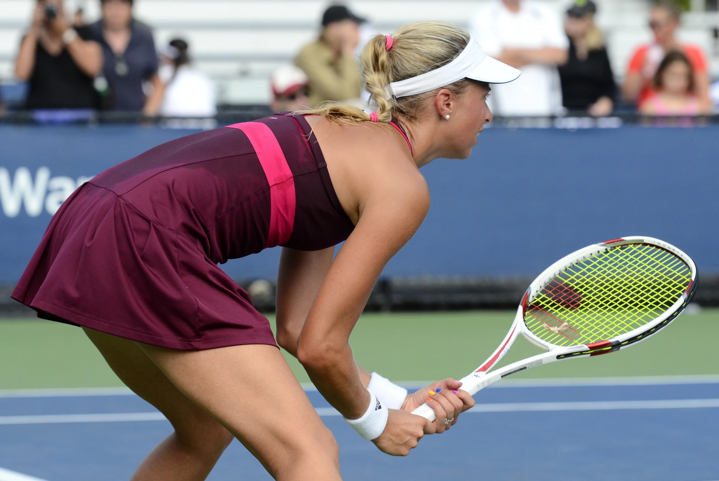 a woman is bending down with a tennis racket