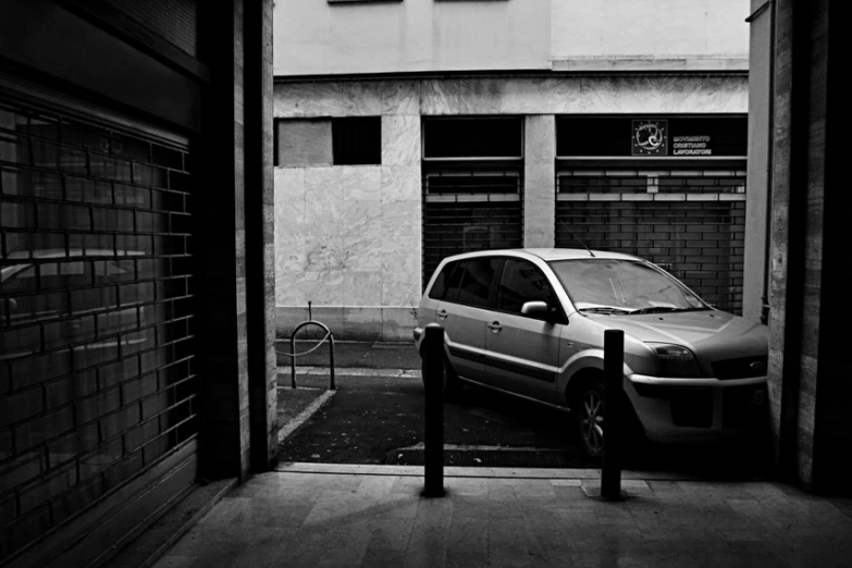 a parked car sitting next to a building near a parking meter