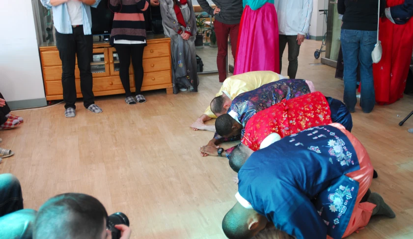 people in the middle of a room, some wearing colorful dresses