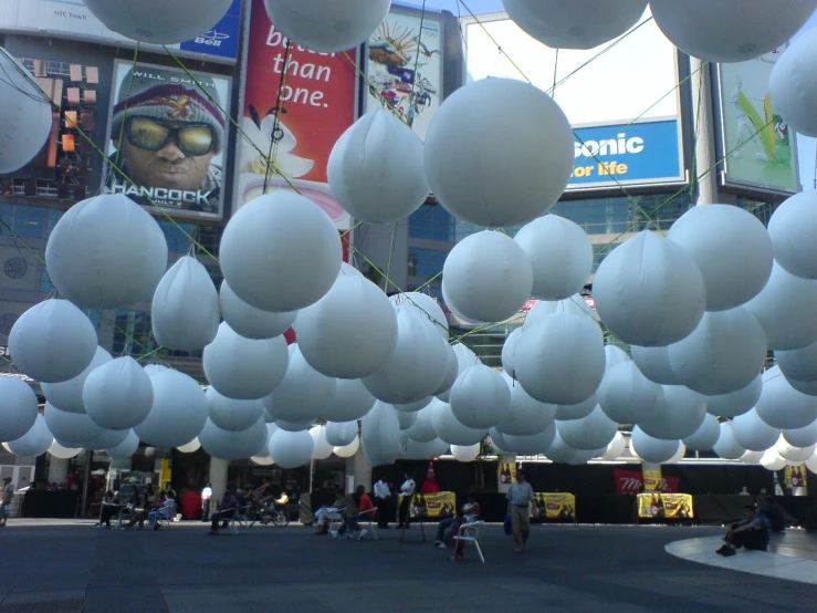 giant white balloons are suspended in the air in front of an arena