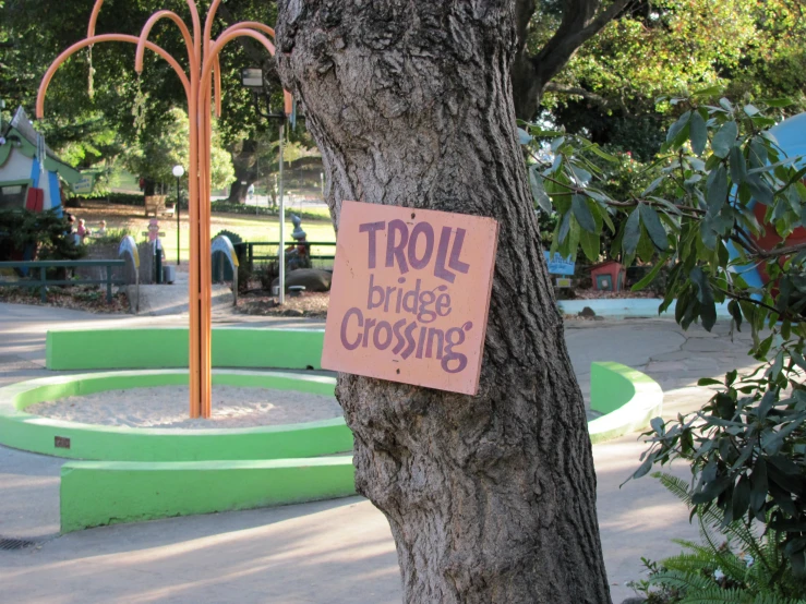 a sign on a tree saying troll price crossing