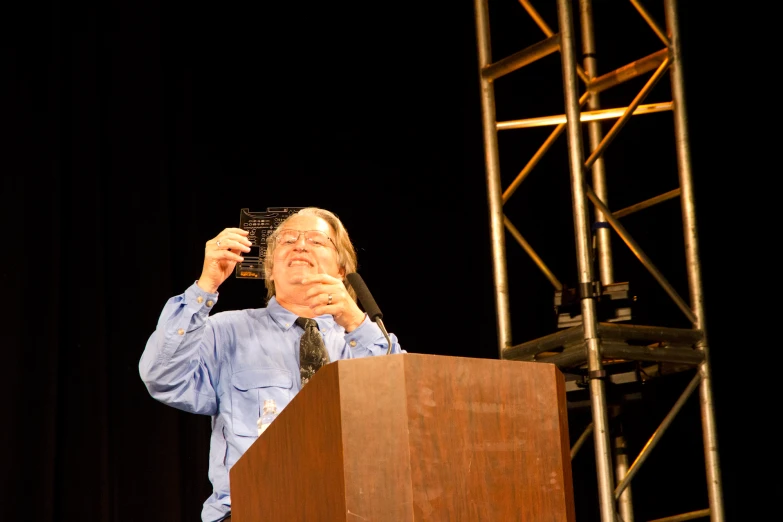 a man holding up his hand up at a podium