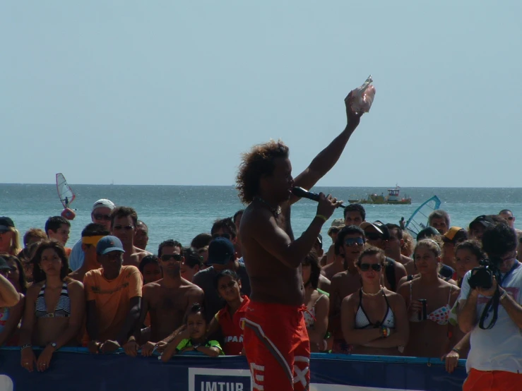 man with tennis racket standing in front of crowd of people