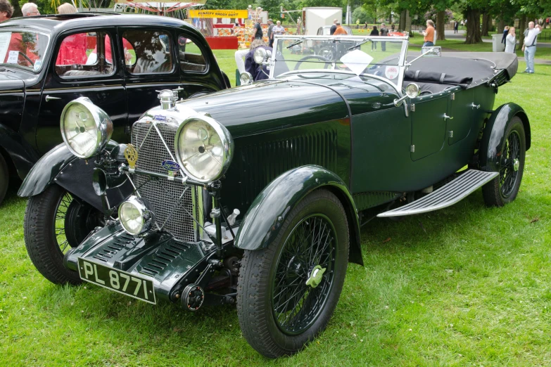 an antique black car parked on the grass