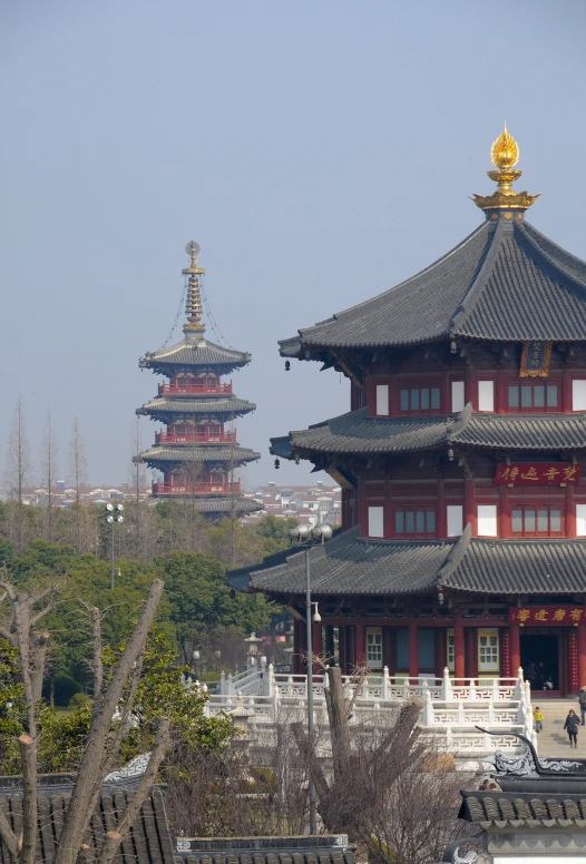 tall red pagodas next to trees with pagoda tops