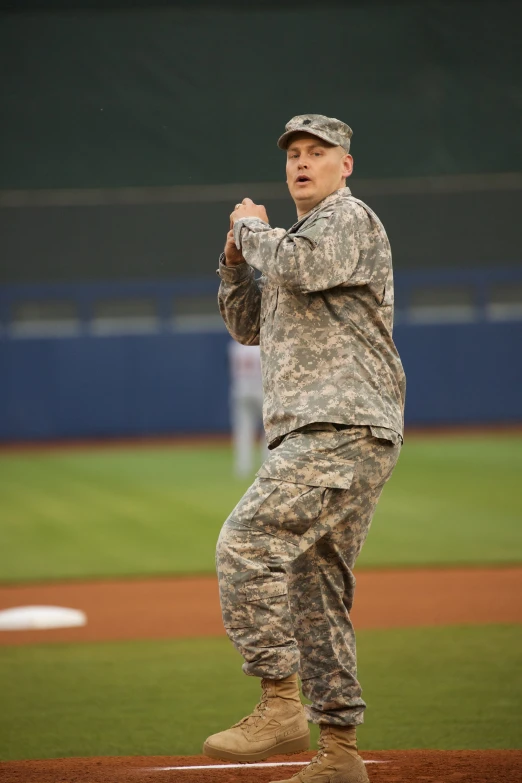 the man in the camouflage jacket throws a baseball