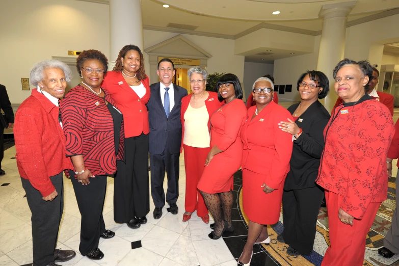 a group of women in red standing on a marble floor