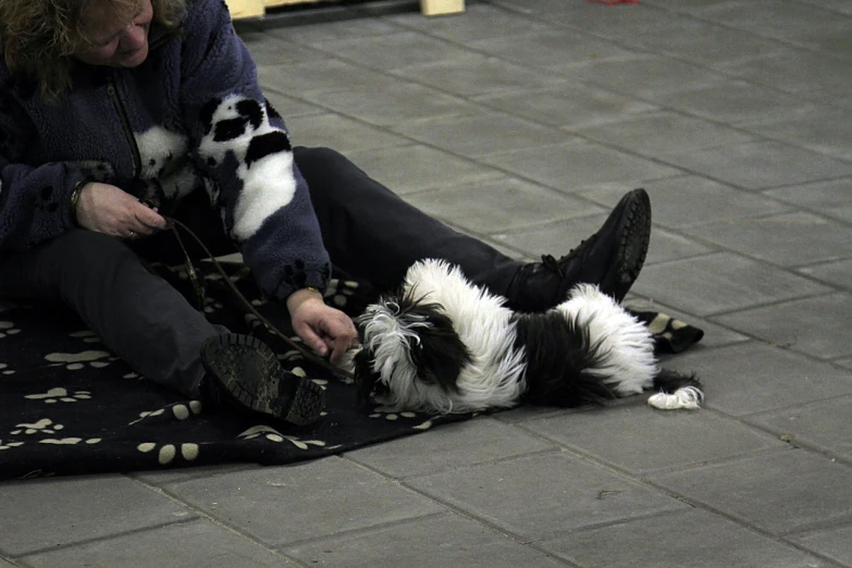 a woman and her dog are relaxing on a tile floor