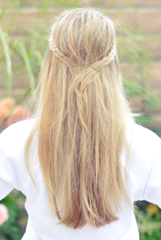 a woman with a half - id hair standing in front of flowers