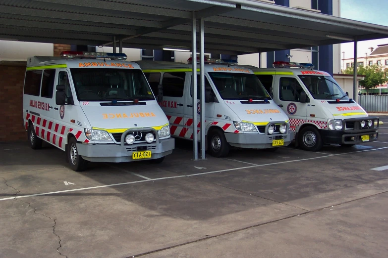 two ambulances that are sitting next to each other in a parking lot