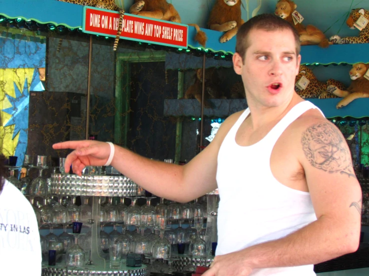 a man standing in front of an assortment of beer cups