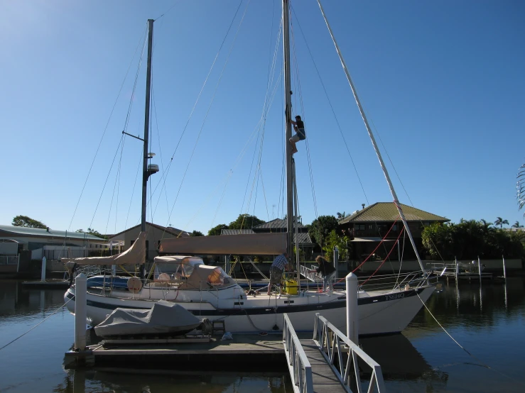 a sail boat parked in the harbor near a dock